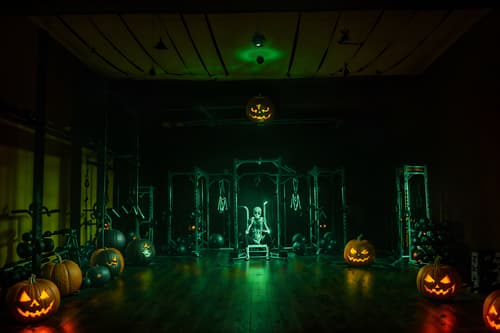 photo from pinterest of halloween-style interior designed (fitness gym interior) with dumbbell stand and crosstrainer and squat rack and bench press and exercise bicycle and dumbbell stand. . with yellow black balloons and lanterns and cobwebs and human skulls and skeletons sitting and standing and cobwebs and spiderwebs and glowing pumpkins. . cinematic photo, highly detailed, cinematic lighting, ultra-detailed, ultrarealistic, photorealism, 8k. trending on pinterest. halloween interior design style. masterpiece, cinematic light, ultrarealistic+, photorealistic+, 8k, raw photo, realistic, sharp focus on eyes, (symmetrical eyes), (intact eyes), hyperrealistic, highest quality, best quality, , highly detailed, masterpiece, best quality, extremely detailed 8k wallpaper, masterpiece, best quality, ultra-detailed, best shadow, detailed background, detailed face, detailed eyes, high contrast, best illumination, detailed face, dulux, caustic, dynamic angle, detailed glow. dramatic lighting. highly detailed, insanely detailed hair, symmetrical, intricate details, professionally retouched, 8k high definition. strong bokeh. award winning photo.